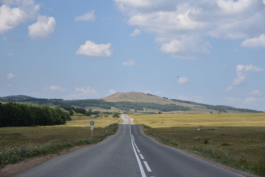 Vista de uma estrada pelo vidro do carro, com seis amostras de película encostadas